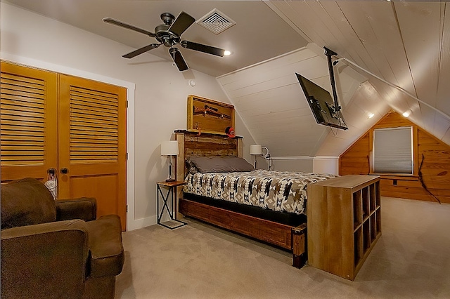 bedroom featuring light carpet, wooden walls, ceiling fan, and lofted ceiling