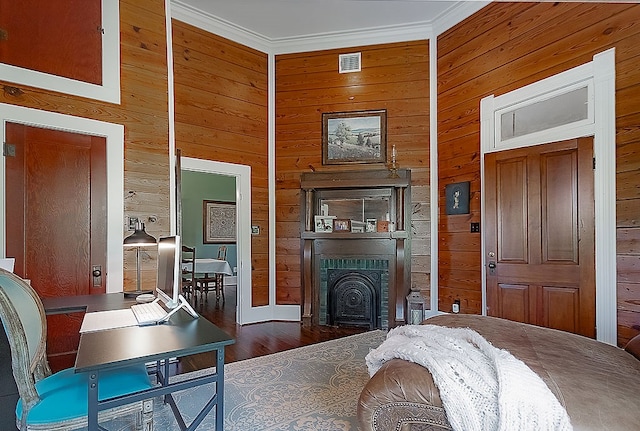 bedroom featuring crown molding, dark wood-type flooring, and wooden walls