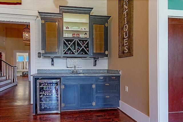 bar featuring dark hardwood / wood-style flooring, beverage cooler, and sink