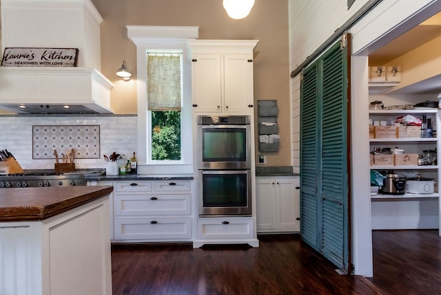 kitchen with backsplash, white cabinets, dark wood-type flooring, and appliances with stainless steel finishes