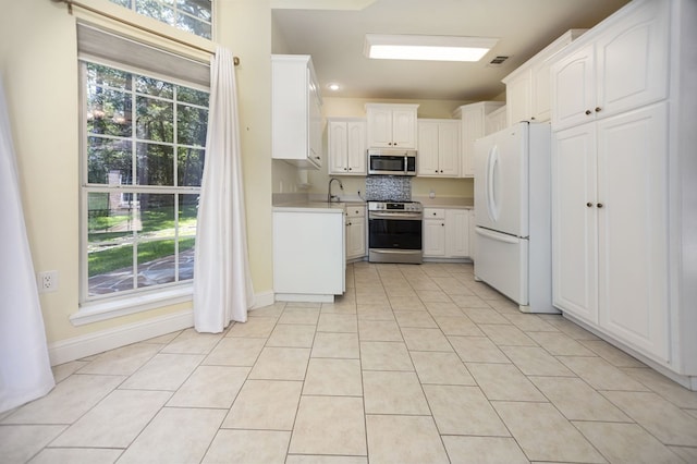 120 Shady Springs Bnd, Lufkin, TX 75901 - kitchen featuring stainless steel appliances, white cabinetry, light countertops, light tile patterned floors, and tasteful backsplash