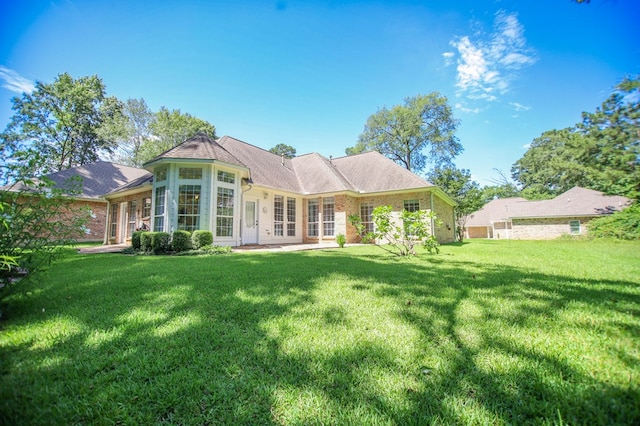 120 Shady Springs Bnd, Lufkin, TX 75901 - back of house featuring a lawn, brick siding, and french doors