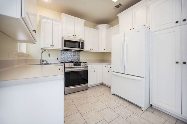 120 Shady Springs Bnd, Lufkin, TX 75901 - kitchen with stainless steel appliances, light tile patterned flooring, white cabinets, and light countertops