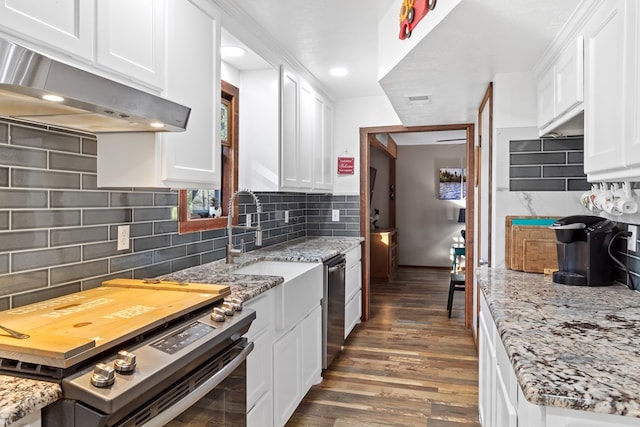 kitchen with white cabinets, stainless steel appliances, light stone counters, and decorative backsplash