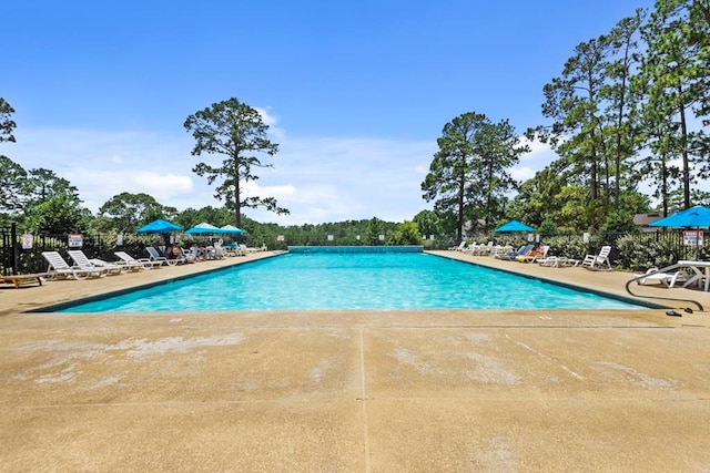 pool featuring fence and a patio area