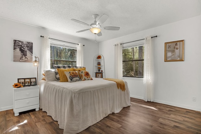 bedroom featuring a textured ceiling, baseboards, and wood finished floors