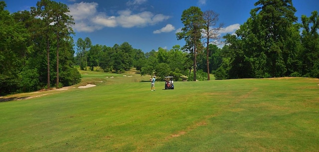view of home's community with golf course view and a lawn