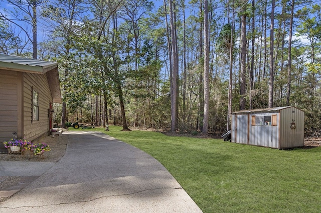 view of yard featuring a shed, an outbuilding, and concrete driveway