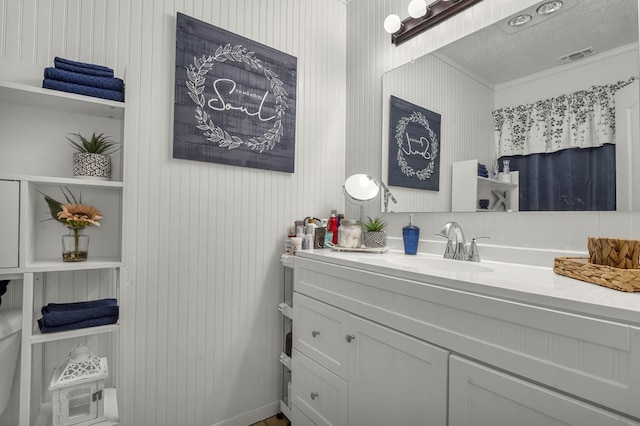bathroom featuring a textured ceiling, visible vents, and vanity