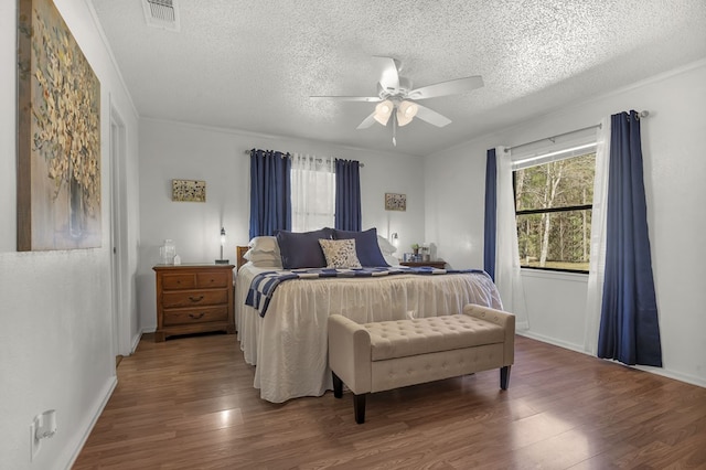 bedroom with multiple windows, visible vents, and wood finished floors