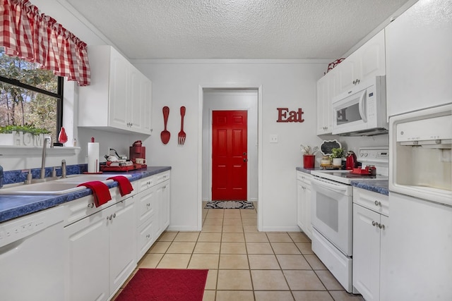 kitchen featuring light tile patterned flooring, a sink, white cabinetry, a textured ceiling, and white appliances