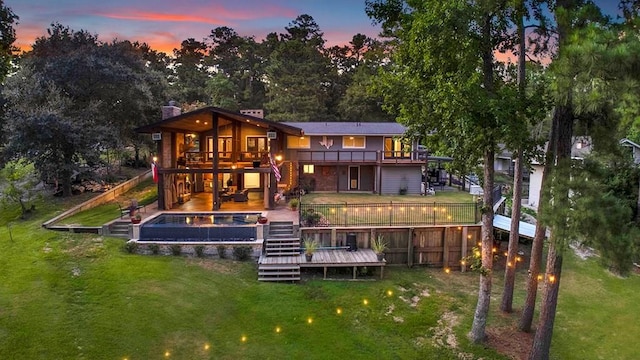 671 Lakeshore Dr, Brookeland, TX 75931 - back of house at dusk featuring stairway, a wooden deck, and a chimney