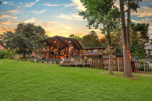 671 Lakeshore Dr, Brookeland, TX 75931 - back of property featuring a lawn, stairway, and a wooden deck