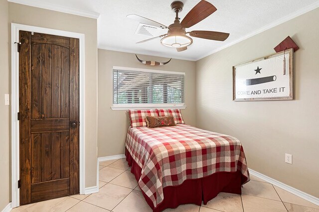 671 Lakeshore Dr, Brookeland, TX 75931 - bedroom with ornamental molding, light tile patterned flooring, and ceiling fan