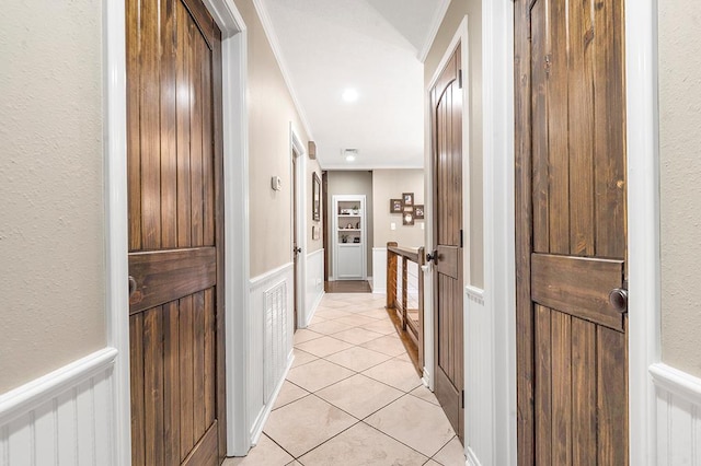 671 Lakeshore Dr, Brookeland, TX 75931 - hallway with crown molding, wainscoting, a decorative wall, and light tile patterned floors