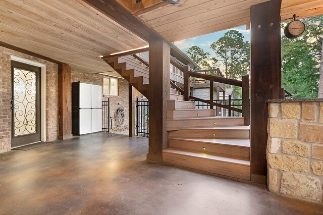 671 Lakeshore Dr, Brookeland, TX 75931 - stairway featuring brick wall, finished concrete floors, plenty of natural light, and wood ceiling