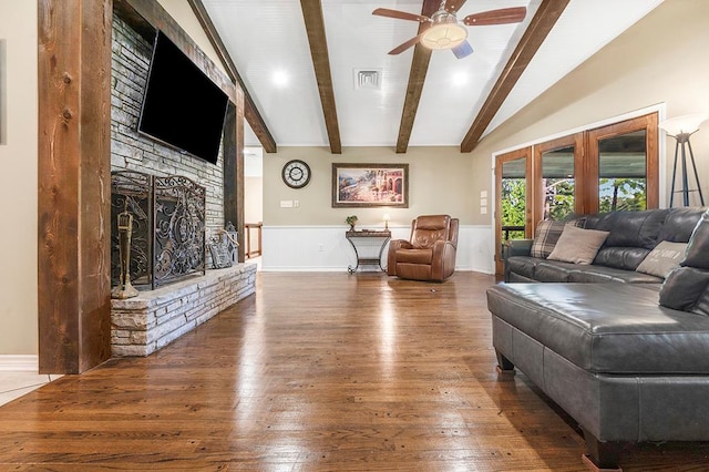 671 Lakeshore Dr, Brookeland, TX 75931 - living area featuring ceiling fan, wood-type flooring, a stone fireplace, and a wainscoted wall