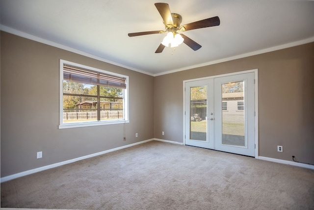 carpeted empty room featuring ceiling fan, crown molding, and french doors