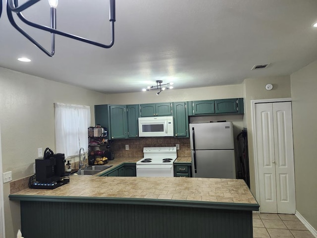 1805 Hanks St, Lufkin, TX 75904 - kitchen with white appliances, a peninsula, light countertops, light tile patterned floors, and backsplash