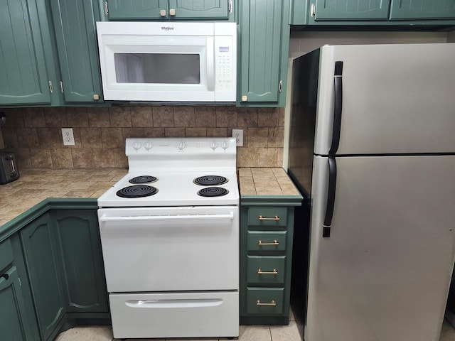 1805 Hanks St, Lufkin, TX 75904 - kitchen with white appliances, green cabinets, tasteful backsplash, and tile counters