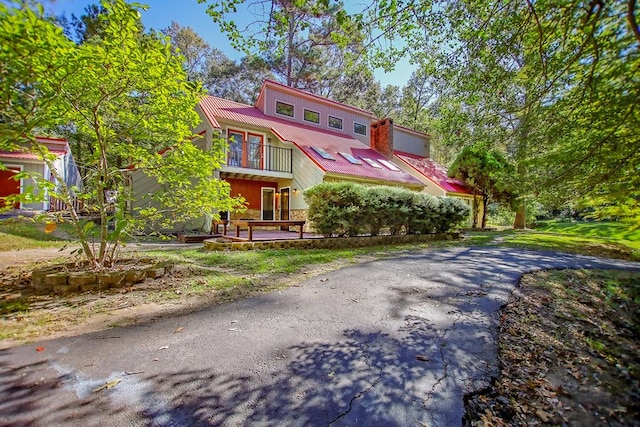 310 Karen Dr, Lufkin, TX 75904 - view of front of property with metal roof, a balcony, and aphalt driveway