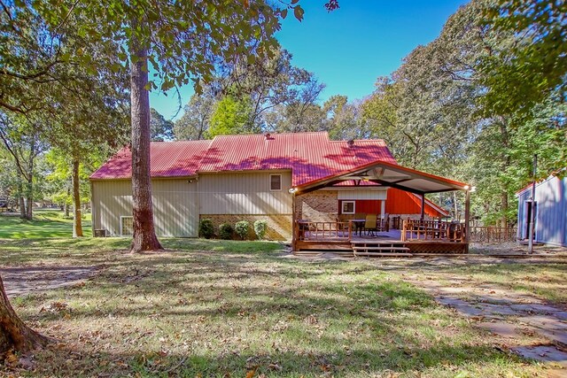 310 Karen Dr, Lufkin, TX 75904 - back of house with a lawn, a wooden deck, brick siding, and metal roof