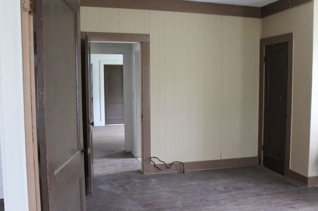 306 S Harrison, San Augustine, TX 75972 - spare room featuring wood finished floors, baseboards, and wooden walls