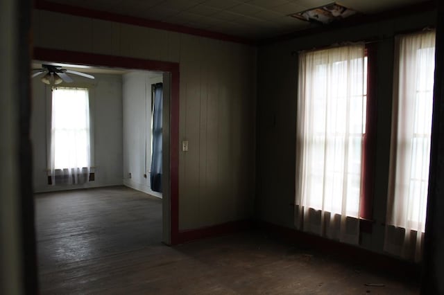 306 S Harrison, San Augustine, TX 75972 - spare room featuring wood finished floors, ceiling fan, wooden walls, and baseboards