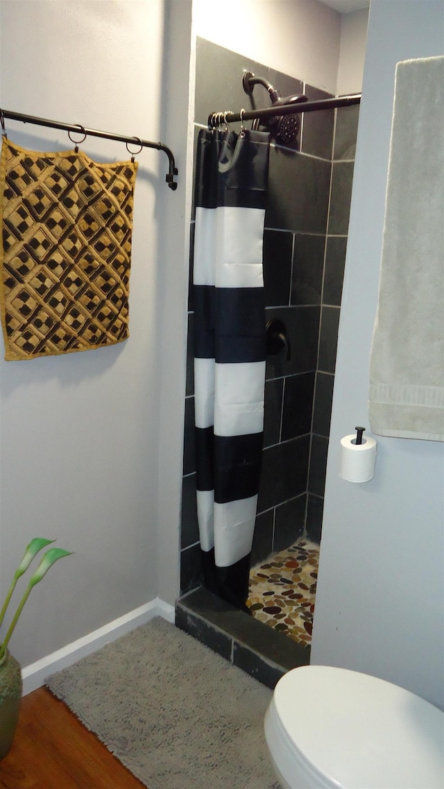 bathroom featuring toilet, hardwood / wood-style floors, and a shower with shower curtain