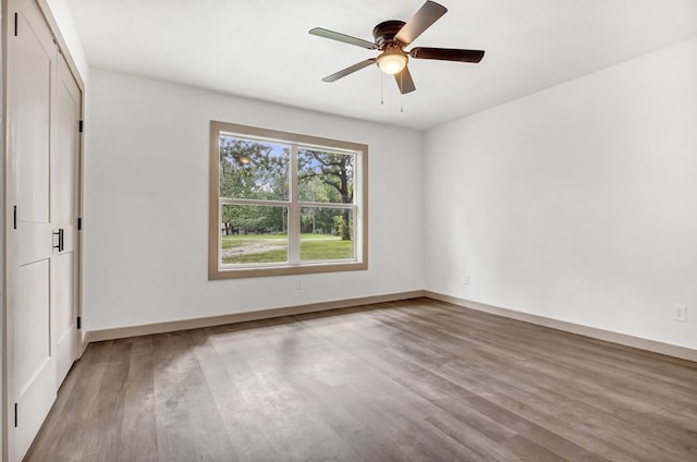 unfurnished bedroom with hardwood / wood-style flooring, ceiling fan, and a closet