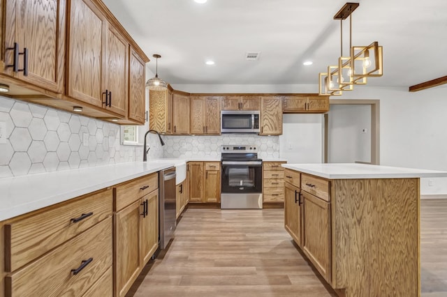 kitchen featuring sink, stainless steel appliances, light hardwood / wood-style flooring, backsplash, and pendant lighting