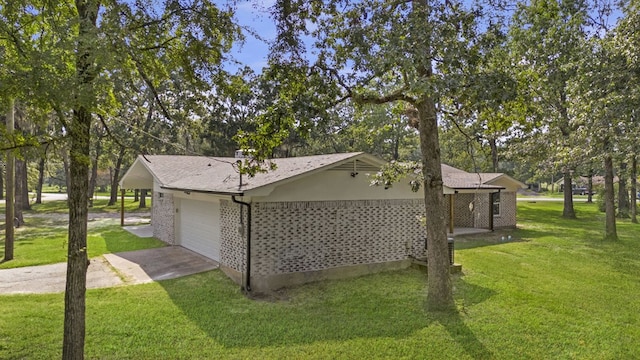 view of side of property featuring a garage and a lawn