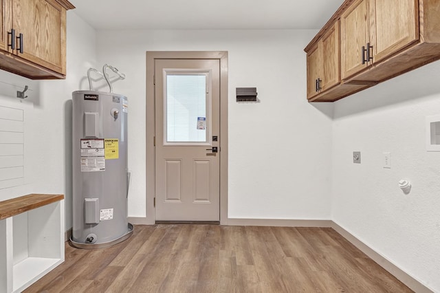 laundry area with electric dryer hookup, cabinets, electric water heater, and light hardwood / wood-style flooring