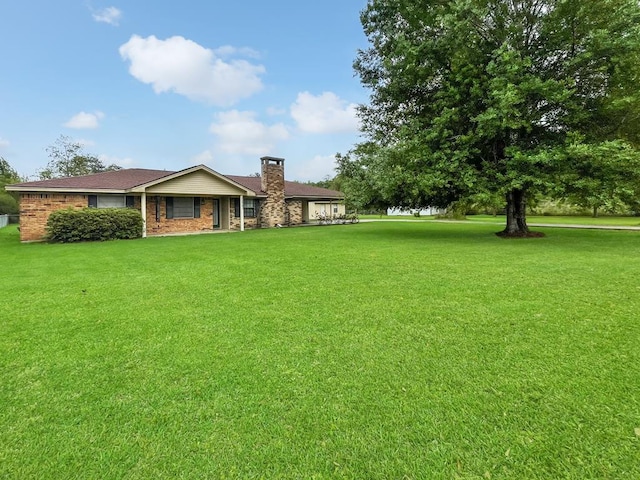 33963 US Highway 96, Buna, TX 77612 - exterior space featuring a front yard, brick siding, and a chimney