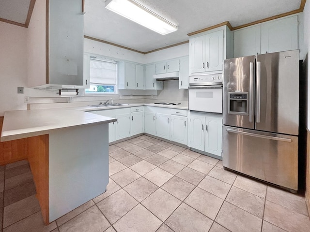33963 US Highway 96, Buna, TX 77612 - kitchen with ornamental molding, white appliances, a peninsula, under cabinet range hood, and a sink