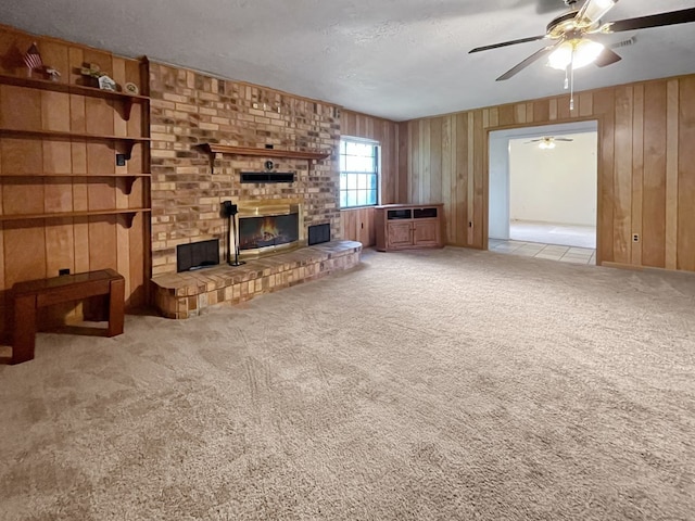 33963 US Highway 96, Buna, TX 77612 - unfurnished living room with wood walls, a fireplace, carpet floors, and ceiling fan