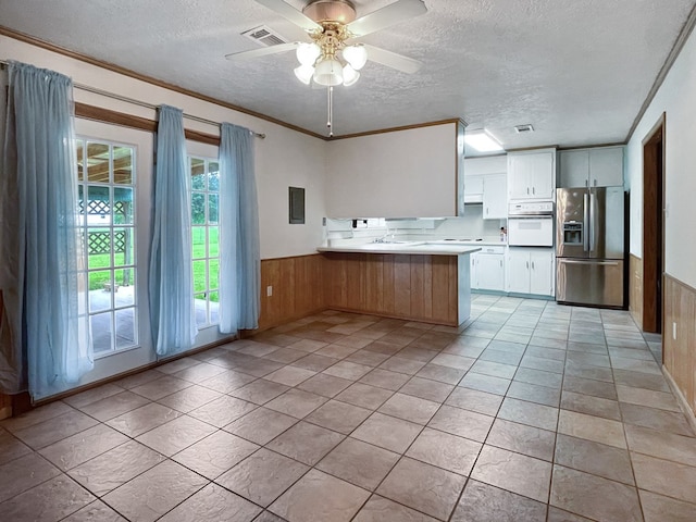 33963 US Highway 96, Buna, TX 77612 - kitchen with white oven, a peninsula, a textured ceiling, visible vents, and stainless steel fridge