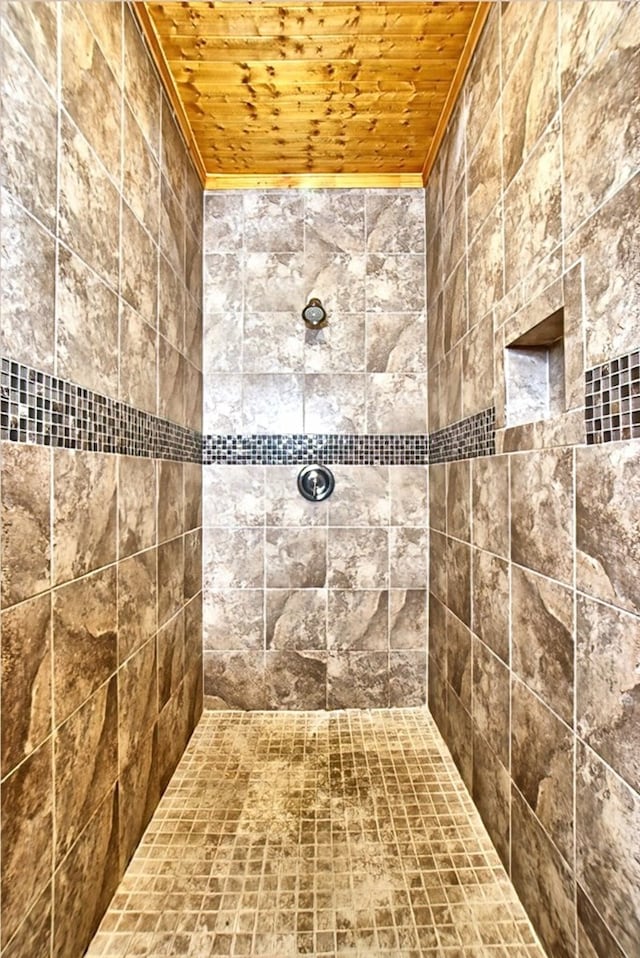 bathroom featuring a tile shower, wooden ceiling, and ornamental molding