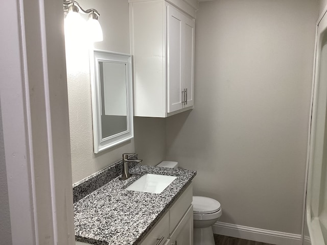 bathroom featuring vanity, hardwood / wood-style floors, and toilet