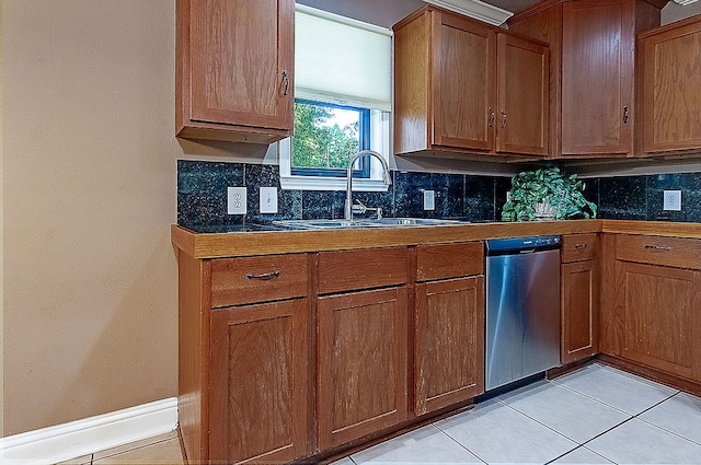 kitchen featuring stainless steel dishwasher, sink, light tile patterned floors, and backsplash