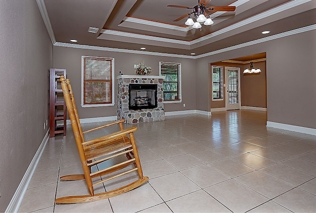 unfurnished living room with a raised ceiling, a stone fireplace, light tile patterned flooring, and ornamental molding