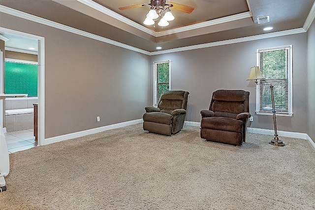 living area featuring ceiling fan, plenty of natural light, and carpet