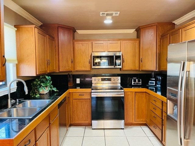 kitchen with appliances with stainless steel finishes, backsplash, ornamental molding, and sink