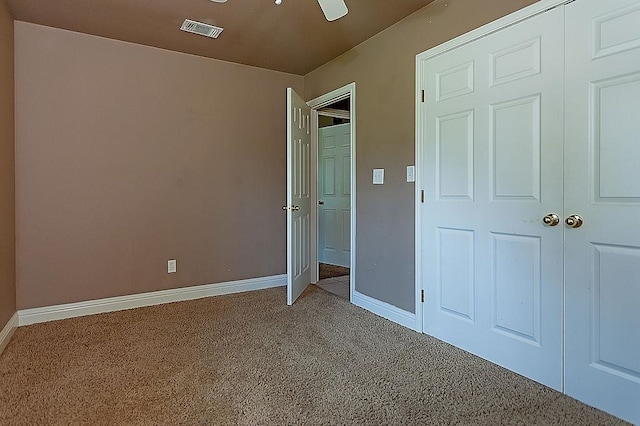 unfurnished bedroom featuring ceiling fan, carpet floors, and a closet