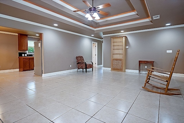 sitting room featuring ceiling fan, light tile patterned flooring, ornamental molding, and a tray ceiling