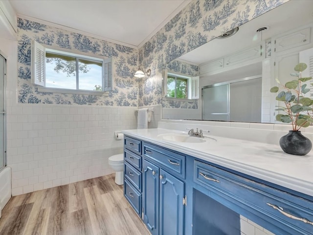 200 Platt Rd, Lufkin, TX 75904 - bathroom with wallpapered walls, tile walls, a shower with shower door, vanity, and a wainscoted wall