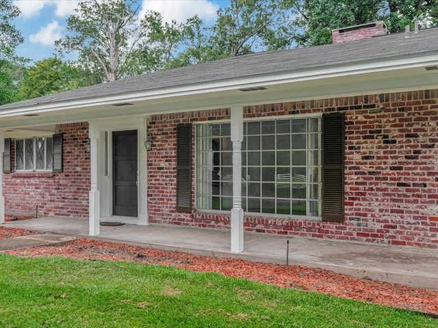 200 Platt Rd, Lufkin, TX 75904 - back of property featuring brick siding, covered porch, and a chimney