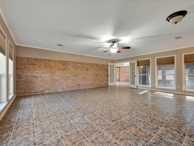 unfurnished room featuring tile patterned floors, visible vents, a ceiling fan, and brick wall