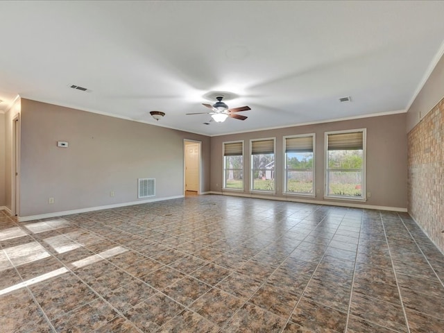 spare room with crown molding, visible vents, ceiling fan, and baseboards
