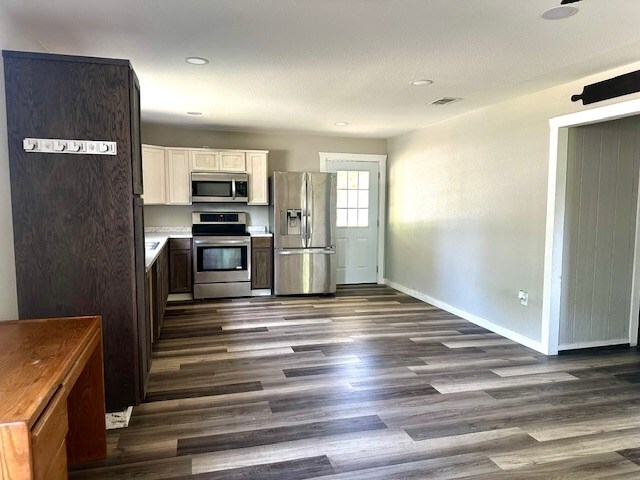 308 Pine, Diboll, TX 75941 - kitchen with baseboards, recessed lighting, white cabinets, dark wood finished floors, and stainless steel appliances